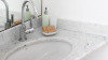 Lavabo in marmo bianco con dispenser di sapone.